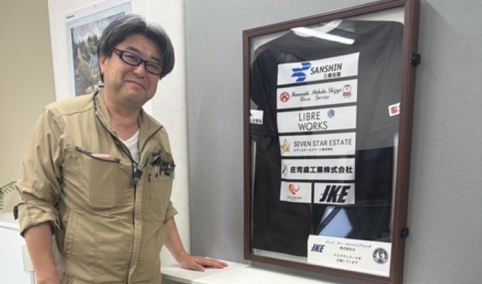 ロゴ入りチームウェアを飾るスポンサー企業の方